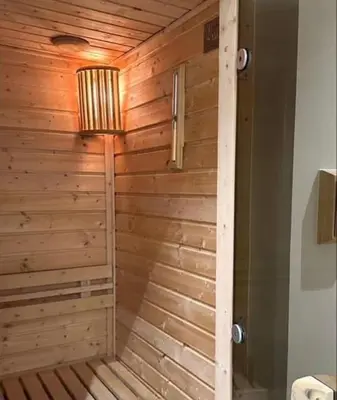 a bathroom with a sauna with a wooden wall at Metro Lounge Studio - Cozy Urban Living in Manila