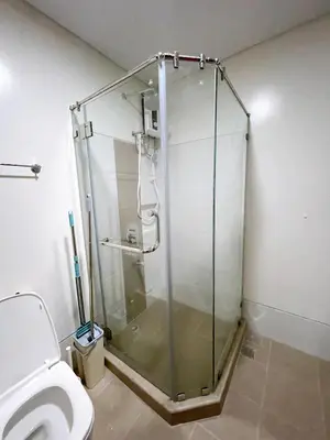 a glass shower in a bathroom with a toilet at Metro Lounge Studio - Cozy Urban Living in Manila