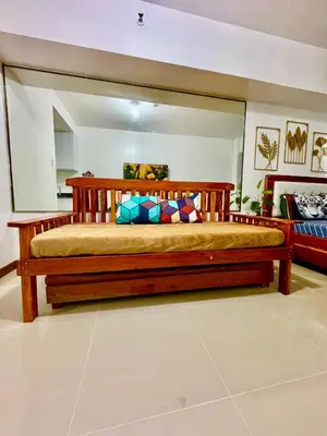 a large wooden bed in a room at Sea Residences Condominium in Manila