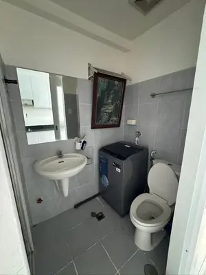 a bathroom with a toilet and a sink at Sea Residences Condominium in Manila