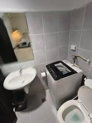 a small bathroom with a toilet and a sink at SEA RESIDENCES CONDOTEL by Tvans in Manila
