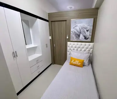 a small bedroom with a bed and a picture of a horse at SMDC Coast Residence in Manila