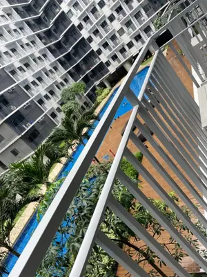 a view from the balcony of a building with palm trees at Stylish and Cozy Condo Near Mall of Asia in Manila