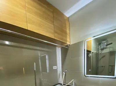 a bathroom with a mirror and a sink and a cabinet at The Nuebe Chalet near SM Moa Pasay City in Manila