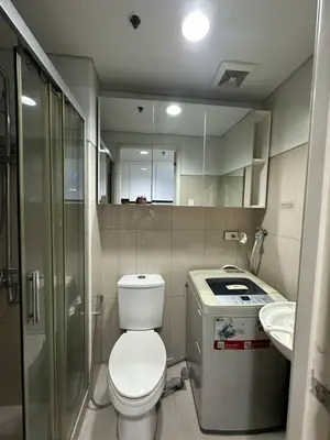a small bathroom with a toilet and a sink at Bellas Place Shell Residences MOA in Manila