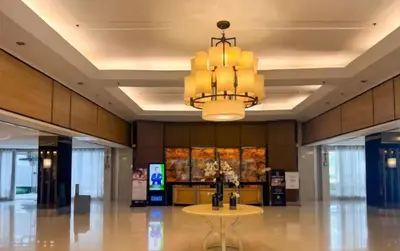 a large lobby with a table and a chandelier at Bellas Place Shell Residences MOA in Manila