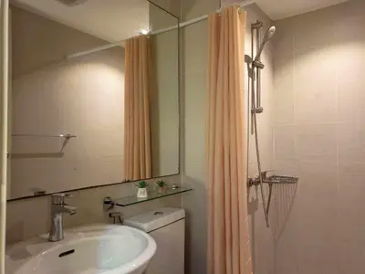 a bathroom with a sink and a toilet and a mirror at 2BR Unit Azure Urban Resort Residences in Manila