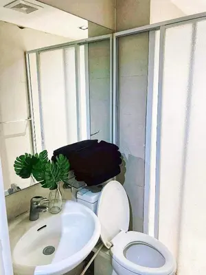 a bathroom with a white toilet and a sink at 2bedroom azure beachview 7 in Manila