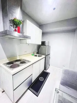 a small kitchen with a stove and a refrigerator at 2bedroom azure beachview 7 in Manila