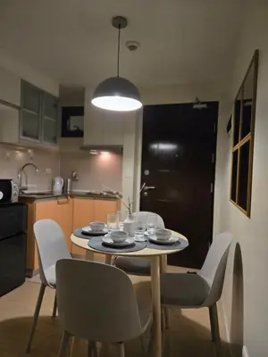 a table and chairs in a kitchen with a table and a light at ScandiCozy Studio NAIA T3 Newport Wifi Pool Netflx in Manila