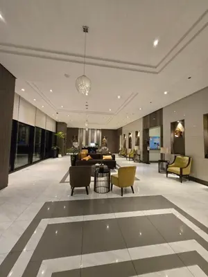 a lobby with chairs and a table in a building at ScandiCozy Studio NAIA T3 Newport Wifi Pool Netflx in Manila