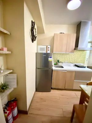 a kitchen with a refrigerator and a sink at 2 bedroom azure cityview 1 in Manila