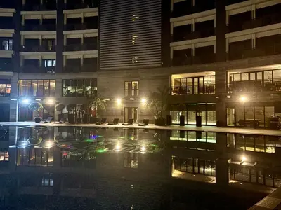 a building with a pool in front of it at night at Sky Piea at Knightsbridge Residences - APARTMENT with Gym Sauna Pool in Manila