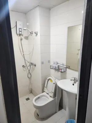 a bathroom with a shower and a toilet and a sink at Bayport Luxhome in Manila