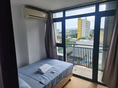a small bed in a room with a large window at Bayport Luxhome in Manila