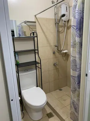 a bathroom with a toilet and a shower at M&L Condotel in Santo Domingo