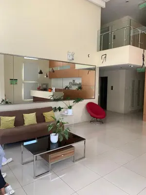 a living room with a couch and a red chair at M&L Condotel in Santo Domingo
