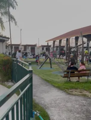 two people sitting on a bench in a park at Transient Room in Dasmariñas