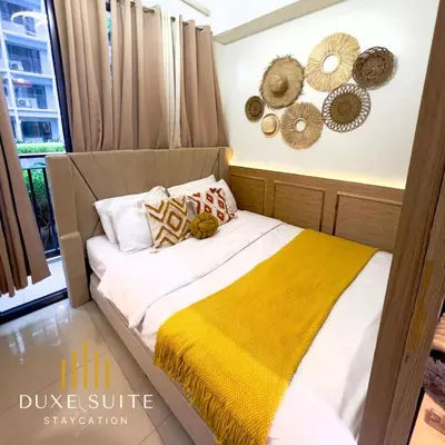 a bedroom with a bed with a yellow blanket at Aesthetic walking distance to MOA,near NAIA AIRPORT with NETFLIX,MINIVIDEOKE,BOARDGAMES-DUXE5 in Manila
