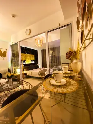 a living room with a table and chairs in a room at Hiraya Vacation at Azure Urban Resorts in Manila