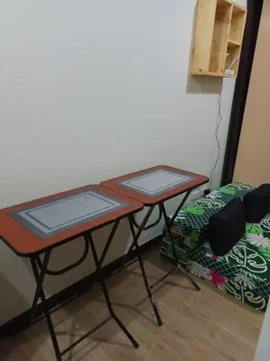 a table with two trays on it next to a bed at Nature Green Room Paseo Verde at Calle Real in Manila