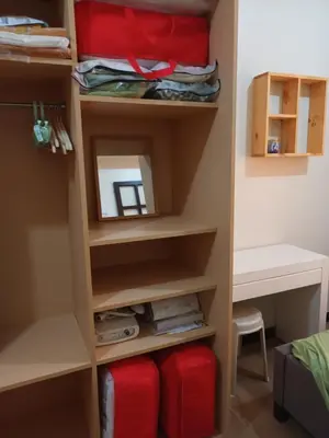 a walk in closet in a bedroom with red luggage at Nature Green Room Paseo Verde at Calle Real in Manila