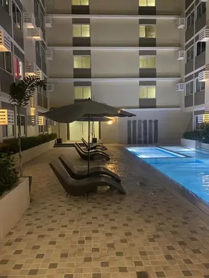 a swimming pool with an umbrella in a building at Cozy Elegance Staycation in Silang