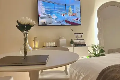 a bedroom with a table and a tv on the wall at Cozy Elegance Staycation in Silang