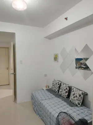 a bedroom with a bed in a white room at Tower C sea residence manolita in Manila