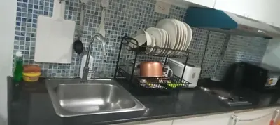 a kitchen counter with a sink and a plate rack at Tower C sea residence manolita in Manila