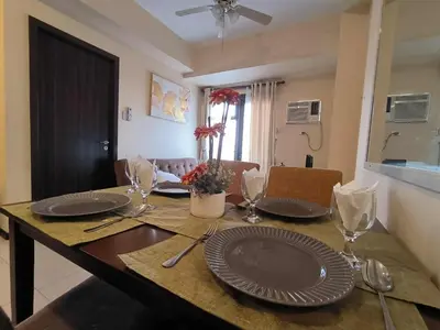 a dining room table with plates and glasses on it at Condo Unit Near Manila Bay, US Embassy & Iconic Tourist Spots in Manila
