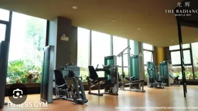 a gym with cardio equipment in a building with large windows at Condo Unit Near Manila Bay, US Embassy & Iconic Tourist Spots in Manila