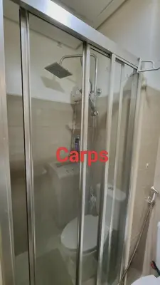 a glass shower with a toilet in a bathroom at Carps Staycation in Manila