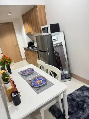 a kitchen with a white table with two plates on it at Unistay Shore 3 Tower 2 10th floor near MOA and AIRPORT in Manila