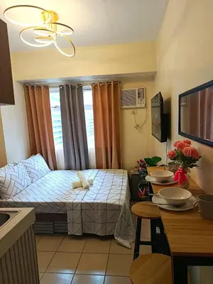 a small room with a bed and a table at g and A condotels in Manila