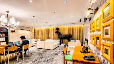 a man sitting at a desk in a room with a computer at Poblacion Stay with Pool Gym Jacuzzi and Pool Table in Manila