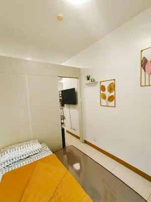 a bedroom with a bed and a flat screen tv at Cozy 2BR Stay Near SM Southmall in Manila
