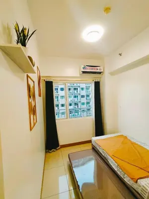 a room with a bed and a window at Cozy 2BR Stay Near SM Southmall in Manila