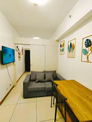 a living room with a couch and a table at Cozy 2BR Stay Near SM Southmall in Manila