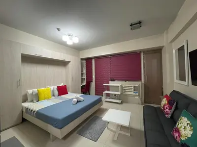 a bedroom with a bed and a couch at Cozy condy at One palm villa across NAIA T3 in Manila