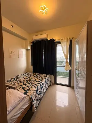 a bedroom with a bed and a large window at Shore 2 Tower 1 Eliel Staycation in Manila