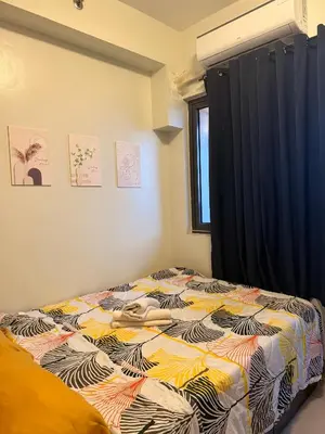 a bedroom with a bed with a colorful comforter at Shore 2 Tower 1 Eliel Staycation in Manila