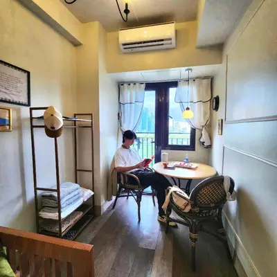 a man sitting at a table in a room at MOA Staycation The Baycourt at Shore Residences Near Mall of Asia IKEA NAIA SMX Convention Center MOA Concert Grounds in Manila