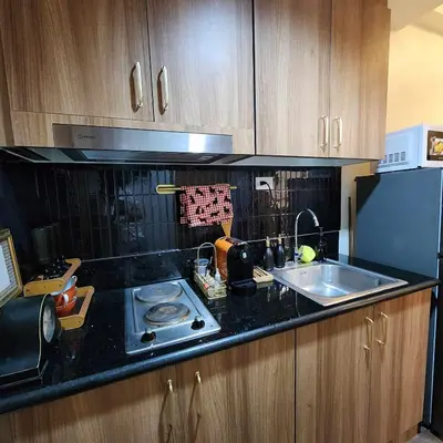 a kitchen counter with a sink and a stove at MOA Staycation The Baycourt at Shore Residences Near Mall of Asia IKEA NAIA SMX Convention Center MOA Concert Grounds in Manila