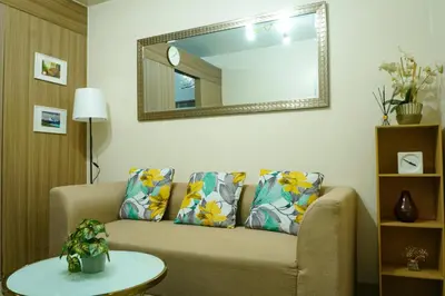 a living room with a couch and a mirror at Shore 2 Residences near MOA, NAIA, PITX in Manila