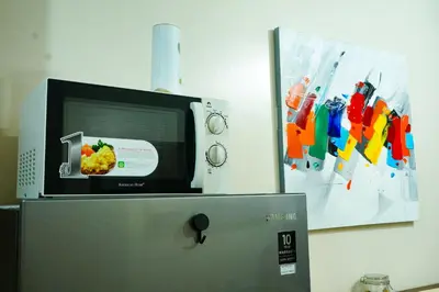 a microwave sitting on top of a refrigerator at Shore 2 Residences near MOA, NAIA, PITX in Manila