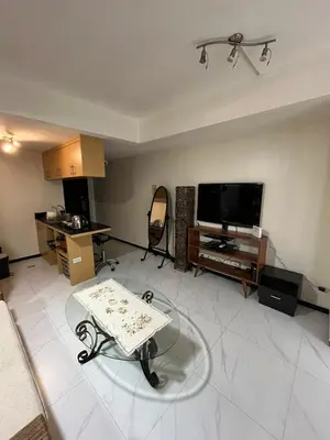 a living room with a table and a tv at A venue Residences 2013 in Manila