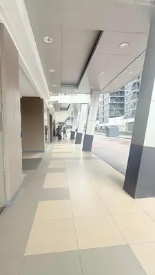 an empty hallway of a building with people walking in it at Shore Residecnes Infront of MoA, Netflix, Wifi in Manila