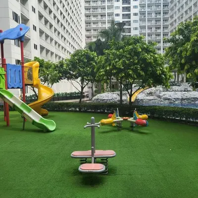 a playground with different types of play equipment on the grass at Shore Residecnes Infront of MoA, Netflix, Wifi in Manila