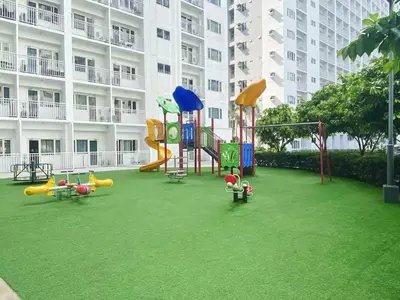 a playground in front of a large apartment building at 1BR 2 Beds Family Friendly near MOA - 9119C in Manila